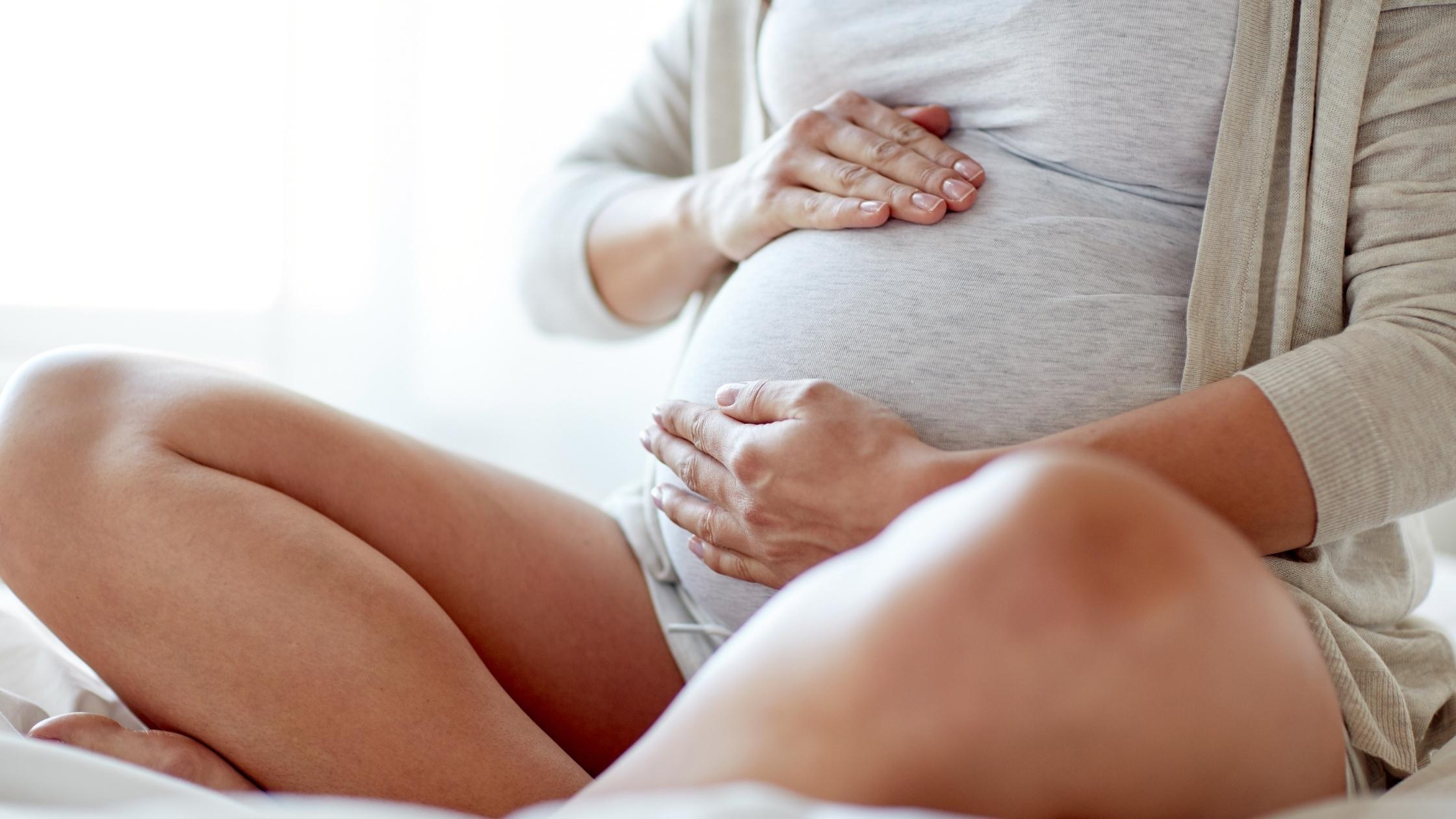 gravid kvinna som känner sitt barns rörelser i magen